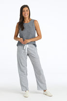 Woman wearing a gray sleeveless top and  blue and white striped pants