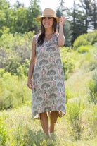 Woman wearing a patterned dress and hat in a natural setting