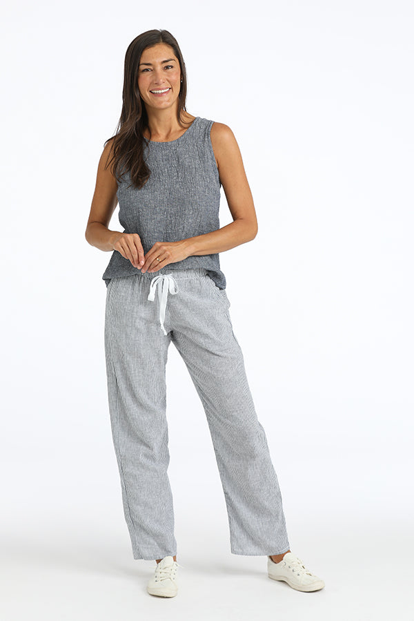 Woman wearing a gray sleeveless top and  blue and white striped pants