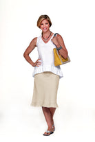 Woman wearing a white top and beige skirt holding a yellow handbag on a white background