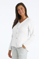 Woman wearing a white button-up gauze shirt on a white background