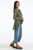 Woman wearing a green jacket and blue jeans on a white background